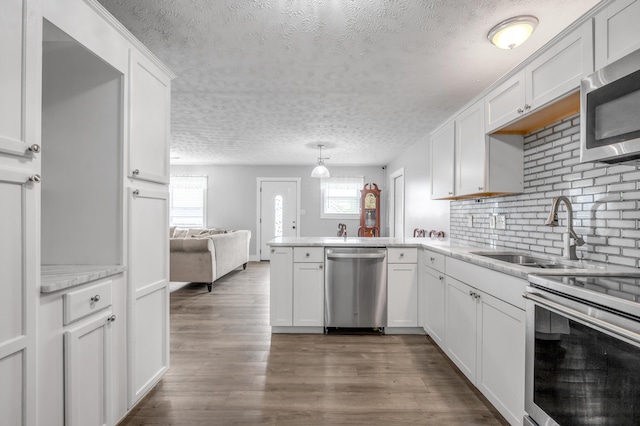 524 Joel St, Lexington, KY 40508 - kitchen with appliances with stainless steel finishes, a textured ceiling, a peninsula, white cabinetry, and light countertops