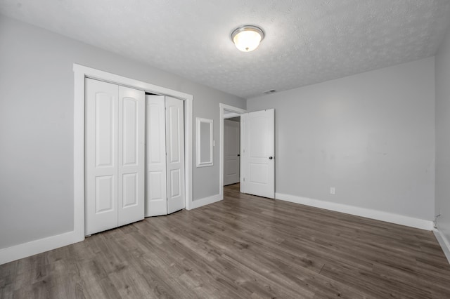 524 Joel St, Lexington, KY 40508 - unfurnished bedroom with wood finished floors, a closet, and a textured ceiling