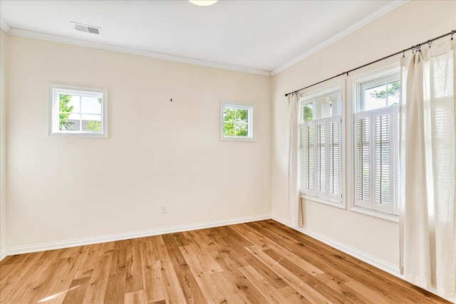 empty room with light wood finished floors, baseboards, and ornamental molding