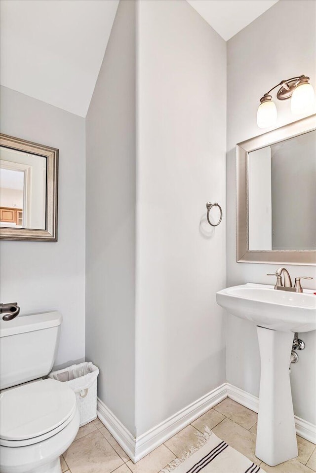 bathroom featuring tile patterned flooring, baseboards, and toilet