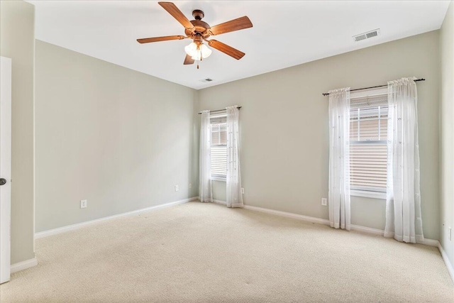 carpeted empty room with a ceiling fan and baseboards
