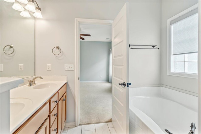 full bathroom featuring a garden tub, ceiling fan, baseboards, tile patterned floors, and double vanity