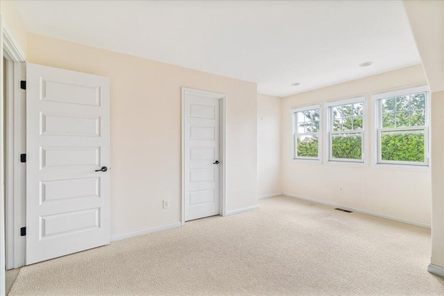 unfurnished bedroom with light carpet and baseboards