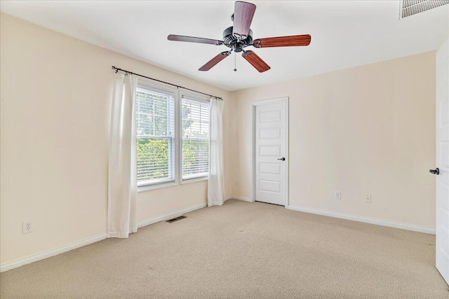 empty room with light colored carpet, baseboards, and ceiling fan