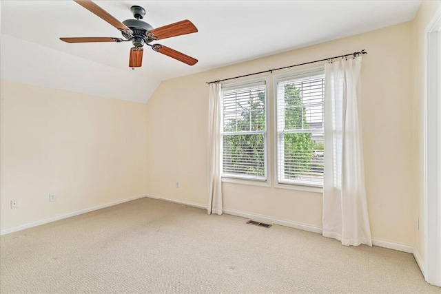 spare room featuring carpet flooring, baseboards, a ceiling fan, and vaulted ceiling