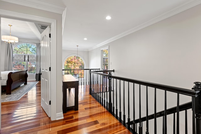 hallway featuring an upstairs landing, hardwood / wood-style floors, a chandelier, crown molding, and recessed lighting
