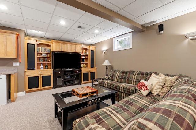 carpeted living room with a paneled ceiling