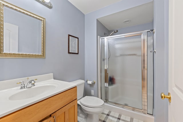 bathroom featuring a shower stall, toilet, vanity, and tile patterned floors