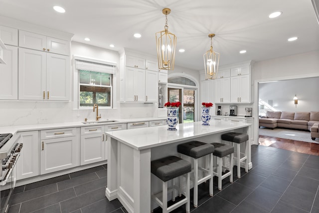 kitchen featuring a sink, white cabinets, light countertops, dark tile patterned flooring, and recessed lighting