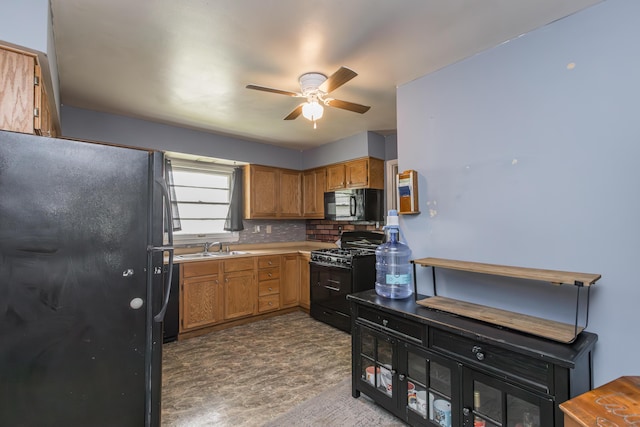 kitchen featuring black appliances, a sink, a ceiling fan, decorative backsplash, and light countertops