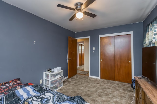 carpeted bedroom featuring a closet, a ceiling fan, and baseboards