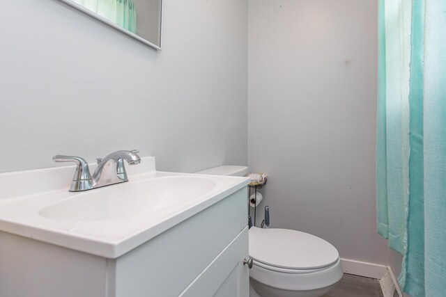 bathroom with vanity, toilet, and baseboards