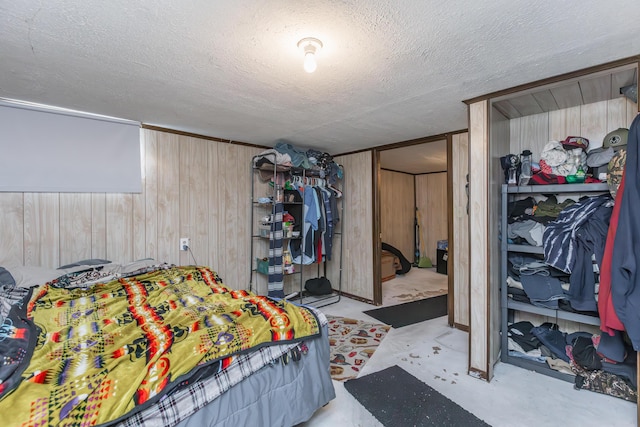 bedroom with wooden walls and a textured ceiling