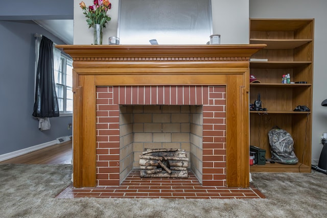 detailed view of carpet flooring, a fireplace, and baseboards
