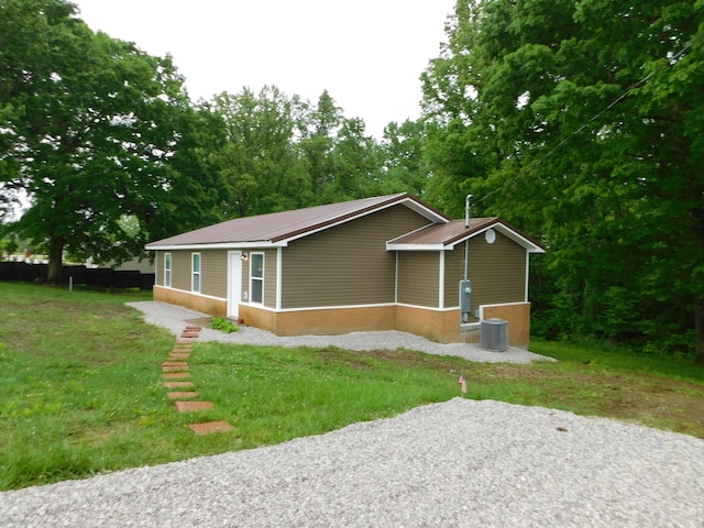 view of front of property featuring brick siding, metal roof, and central air condition unit