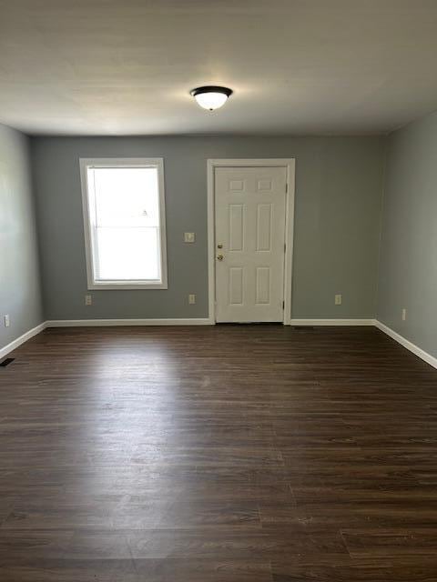 foyer featuring baseboards and dark wood-style floors
