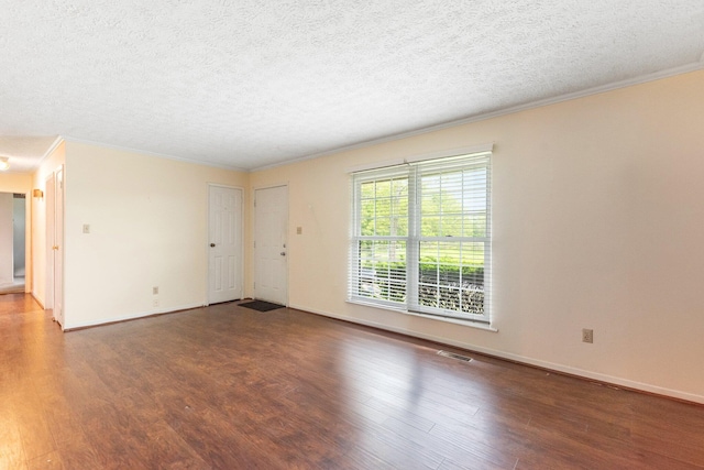 spare room featuring wood finished floors, crown molding, a textured ceiling, and baseboards