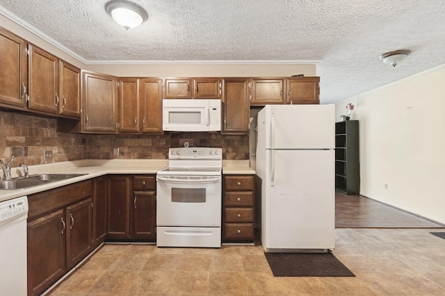 kitchen with white appliances, a textured ceiling, a sink, backsplash, and light countertops