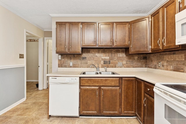 kitchen featuring white appliances, a sink, backsplash, light countertops, and a textured ceiling