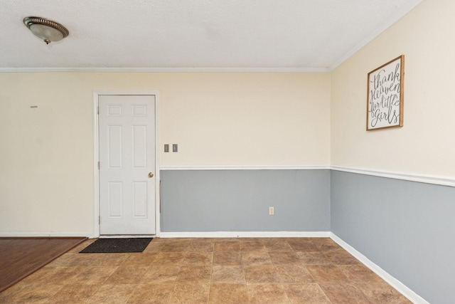 spare room with ornamental molding and baseboards