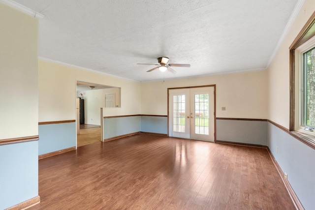spare room with french doors, wood finished floors, healthy amount of natural light, a ceiling fan, and a textured ceiling