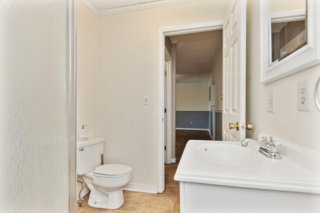 bathroom with toilet, tile patterned flooring, vanity, and crown molding