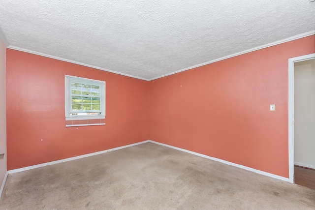 spare room with crown molding, baseboards, a textured ceiling, and carpet floors