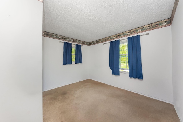 carpeted spare room with a textured ceiling