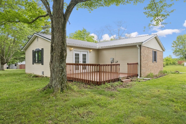 back of property with a deck, a yard, french doors, and metal roof