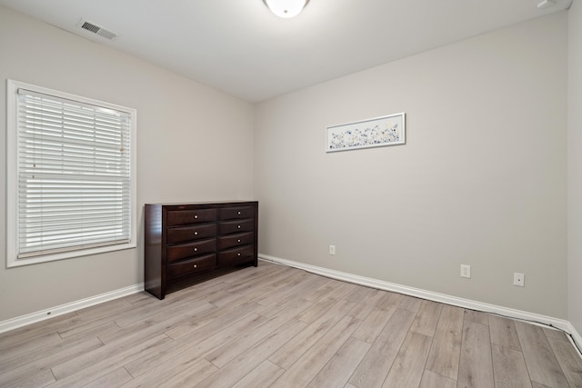 spare room with light wood finished floors and baseboards