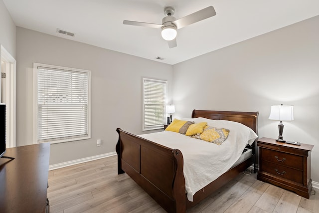 bedroom with light wood-style floors, baseboards, and a ceiling fan