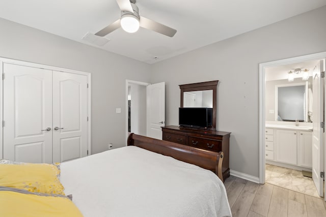 bedroom with a sink, a closet, connected bathroom, a ceiling fan, and baseboards