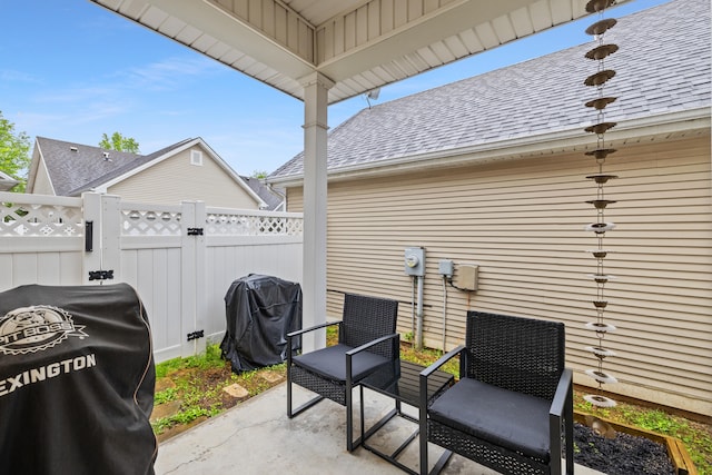 view of patio with fence, area for grilling, and a gate