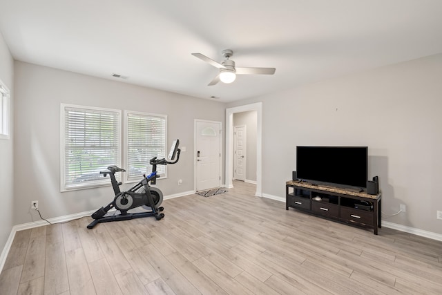 workout room with a ceiling fan, light wood-style floors, and baseboards