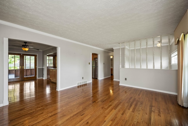 spare room featuring wood finished floors, a ceiling fan, a textured ceiling, baseboards, and french doors