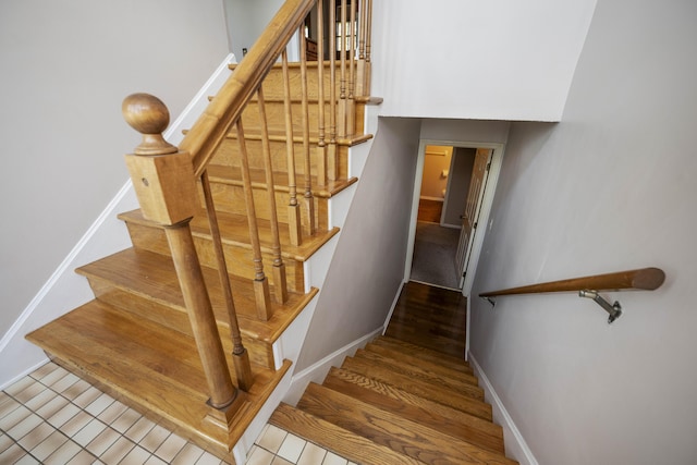 stairway featuring baseboards and tile patterned flooring
