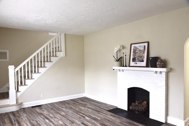 605 Prospect St, Berea, KY 40403 - unfurnished living room with wood finished floors, a textured ceiling, stairway, and baseboards