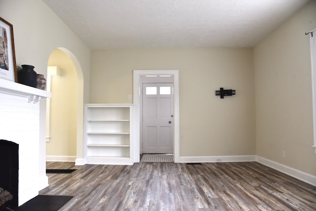 605 Prospect St, Berea, KY 40403 - entrance foyer with wood finished floors, arched walkways, baseboards, and a brick fireplace