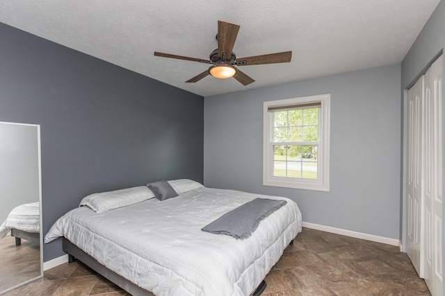 387 W Ila Ave, Danville, KY 40422 - bedroom with a closet, baseboards, stone finish floors, a textured ceiling, and ceiling fan