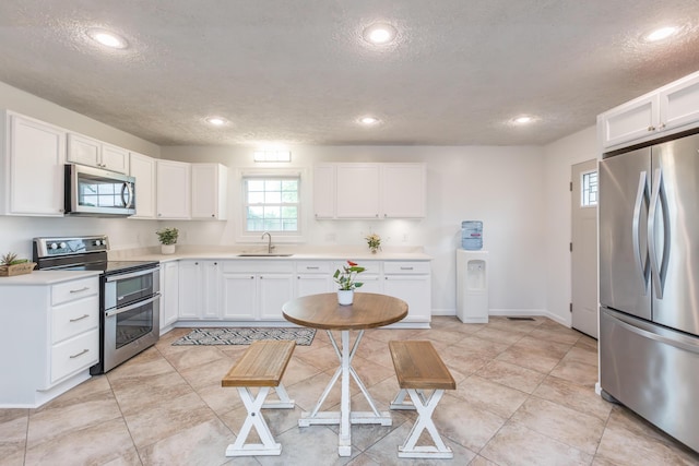 387 W Ila Ave, Danville, KY 40422 - kitchen with stainless steel appliances, a sink, a textured ceiling, white cabinetry, and recessed lighting