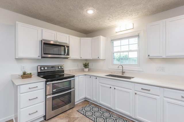 387 W Ila Ave, Danville, KY 40422 - kitchen with appliances with stainless steel finishes, a sink, a textured ceiling, white cabinets, and light countertops