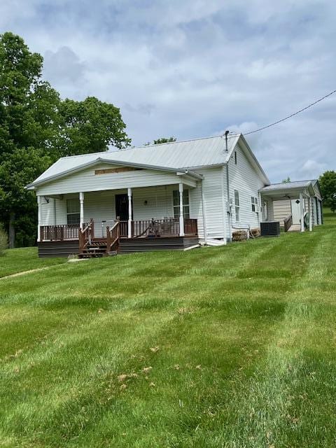 back of house with a porch, cooling unit, and a lawn