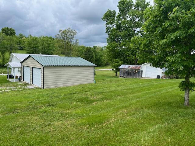 view of grassy yard featuring an outdoor structure and a garage