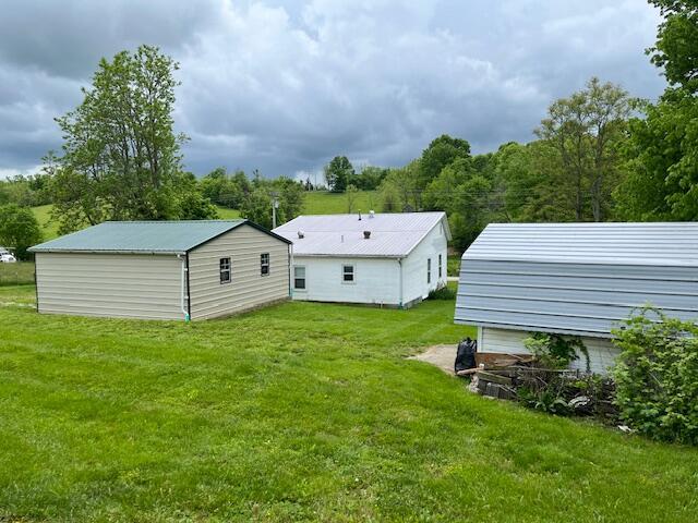 rear view of house with a yard and an outdoor structure