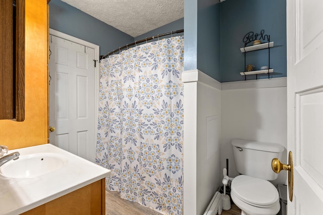 bathroom featuring toilet, a textured ceiling, wood finished floors, curtained shower, and vanity