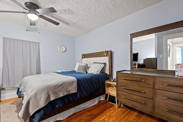 bedroom featuring wood finished floors, a textured ceiling, and ceiling fan