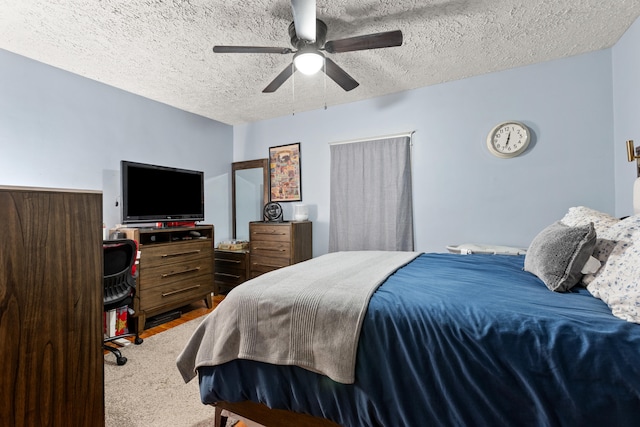 bedroom featuring a textured ceiling, ceiling fan, and carpet flooring