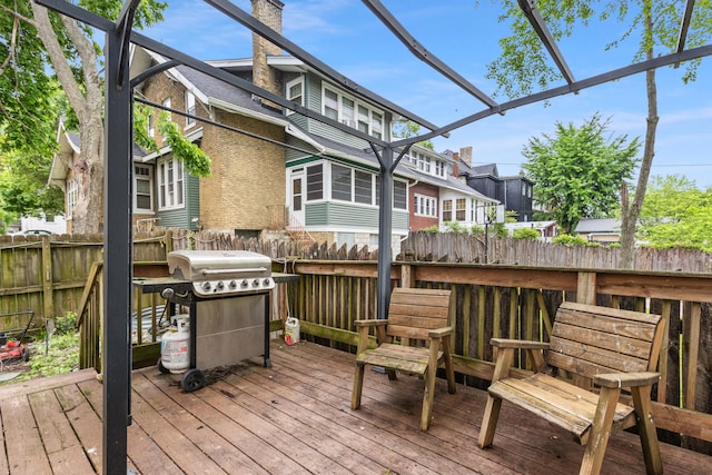 wooden terrace featuring grilling area, fence, and a residential view