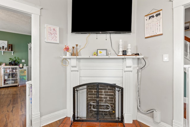 detailed view of a fireplace, baseboards, and wood finished floors