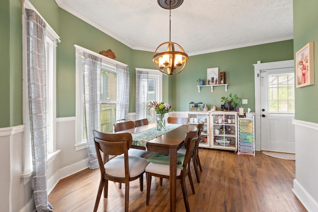 dining room featuring a chandelier, hardwood / wood-style flooring, a textured ceiling, and crown molding